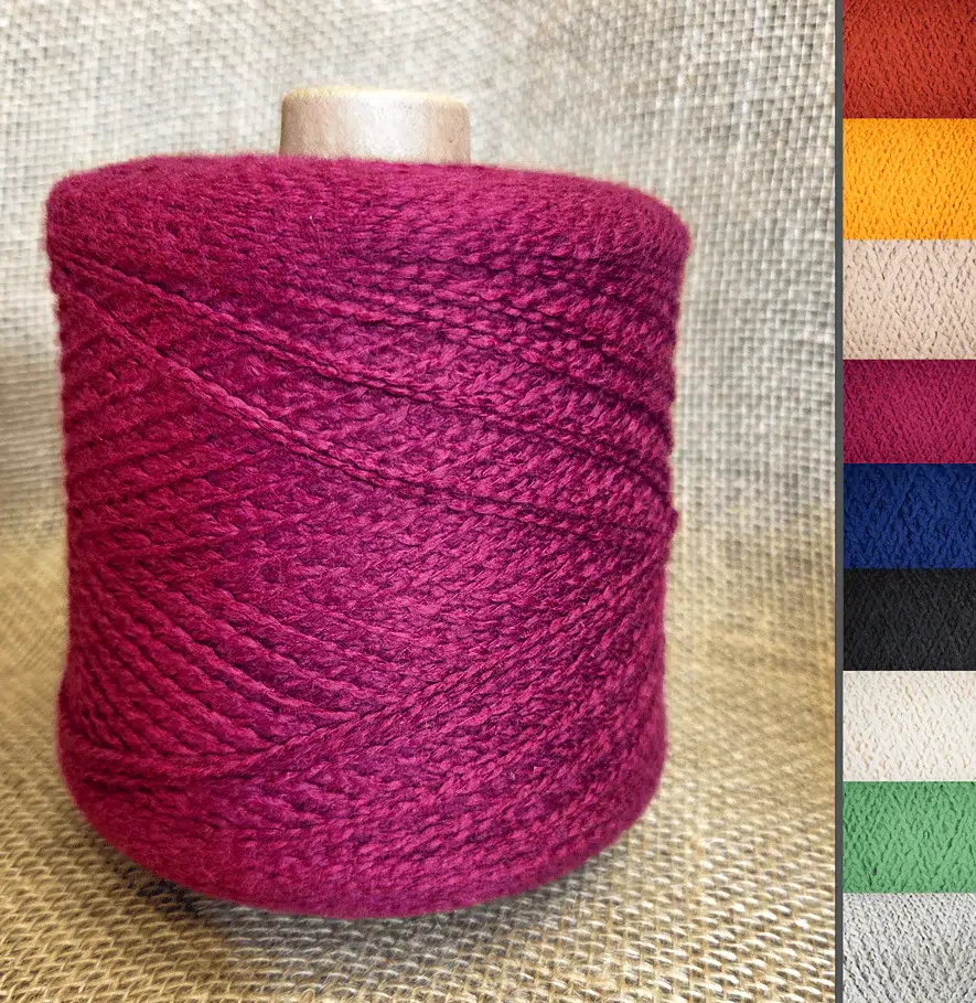 Magenta yarn spool on a beige fabric background with color swatches along the right edge.